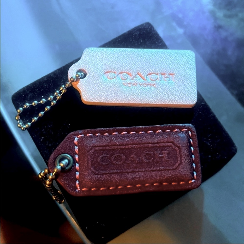 Coach Purse Charms burgundy is slightly faded.Small little tags grab them now 🔥🤩